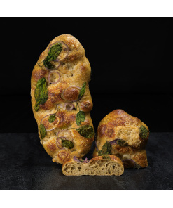 Hausgemachte Herbst-Focaccia mit buntem saisonalem Gemüse, aromatischen Kräutern und kunstvoller Dekoration, hochwertig präsentiert.