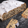Saftiger Schoko-Stollen mit vielen Schokostückchen und einer Schicht Puderzucker, angeschnitten und dekorativ präsentiert.