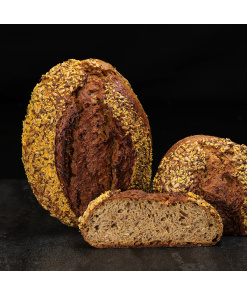 Hausgemachtes Dinkel-Leinöl-Quark-Brot mit aromatischer Kruste, goldenen Körnern und feinporiger Krume, hochwertig präsentiert.