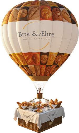 Heißluftballon mit Bäckerei-Branding "Brot & Æhre" und gedecktem Frühstückstisch mit Brot und Gebäck